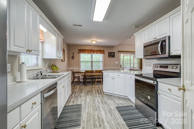kitchen featuring white cabinets, a sink, visible vents, stainless steel appliances, and light countertops