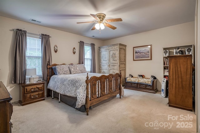 carpeted bedroom featuring a ceiling fan and visible vents