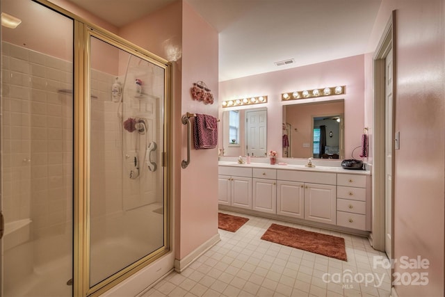 bathroom featuring visible vents, a shower stall, and a sink