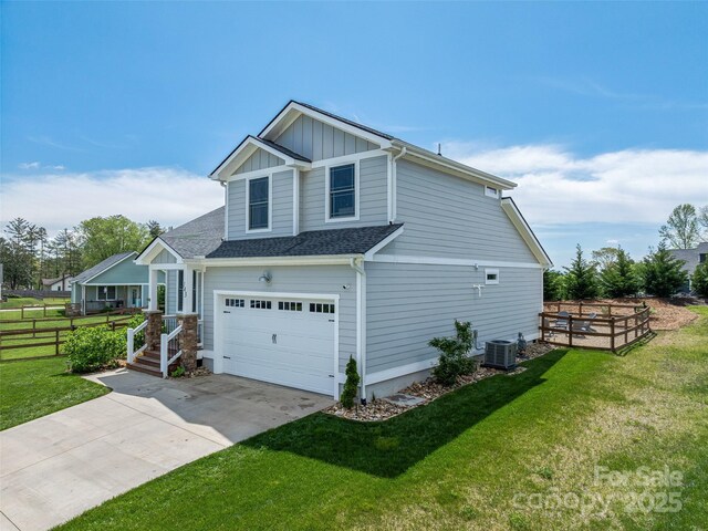 view of property exterior with board and batten siding, a lawn, driveway, and fence