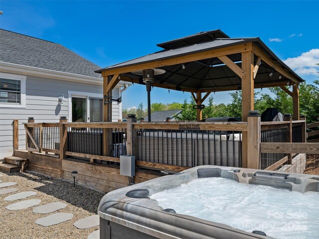 wooden terrace with a gazebo and a hot tub