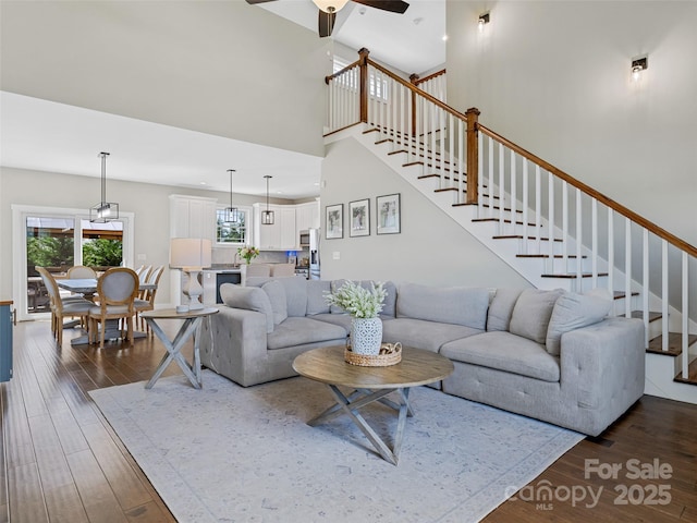living room featuring ceiling fan, stairs, and wood finished floors