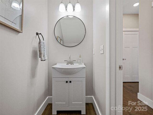 bathroom with baseboards, wood finished floors, and vanity