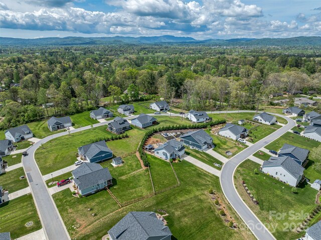 bird's eye view featuring a mountain view, a view of trees, and a residential view