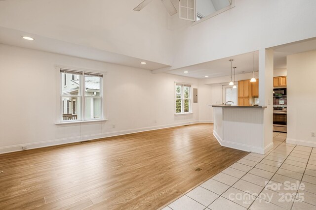 19 Castle St, Asheville, NC 28803 - unfurnished living room featuring light wood-style floors, recessed lighting, baseboards, and ceiling fan