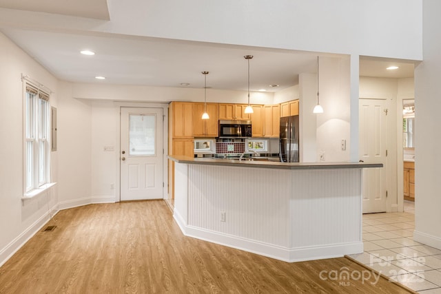 19 Castle St, Asheville, NC 28803 - kitchen featuring stainless steel microwave, fridge, a peninsula, baseboards, and light wood-type flooring