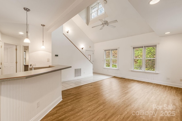 19 Castle St, Asheville, NC 28803 - unfurnished living room featuring light wood-type flooring, high vaulted ceiling, ceiling fan, recessed lighting, and baseboards
