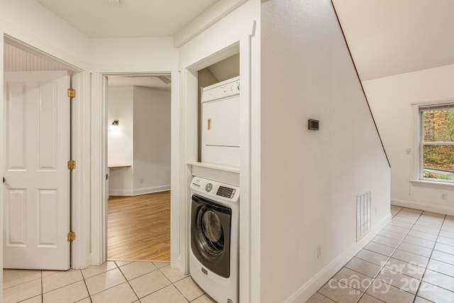 19 Castle St, Asheville, NC 28803 - washroom with light tile patterned floors, stacked washer and clothes dryer, and baseboards