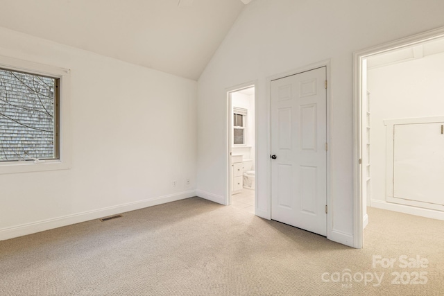 19 Castle St, Asheville, NC 28803 - unfurnished bedroom with light colored carpet, lofted ceiling, connected bathroom, and baseboards