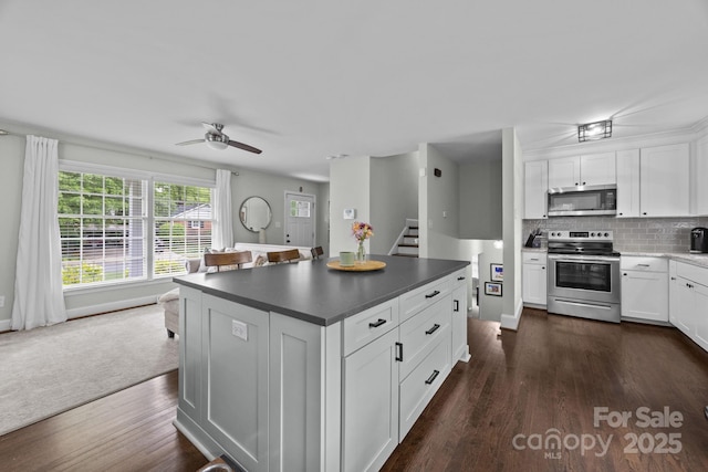 2100 Shadyview Dr, Charlotte, NC 28210 - kitchen featuring stainless steel appliances, ceiling fan, dark wood finished floors, dark countertops, and white cabinets