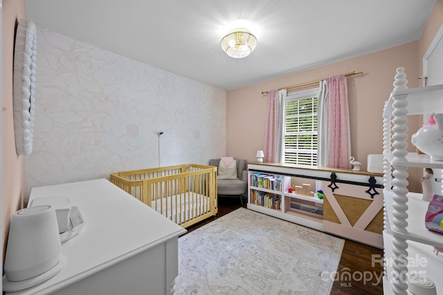 2100 Shadyview Dr, Charlotte, NC 28210 - bedroom with wallpapered walls, wood finished floors, a crib, and an accent wall