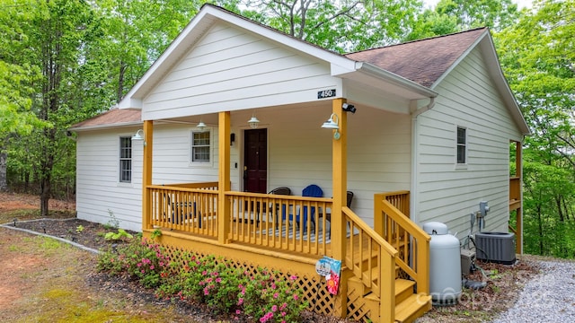view of front of property featuring roof with shingles and central AC