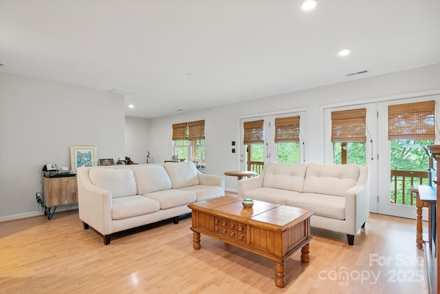 living room featuring recessed lighting, baseboards, light wood-type flooring, and visible vents