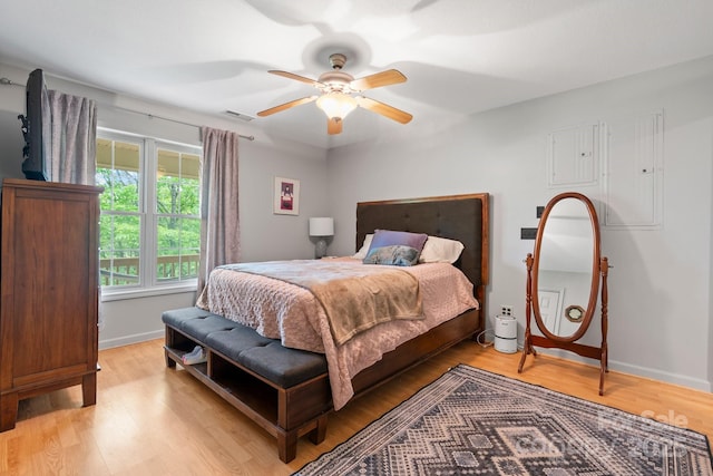 bedroom featuring baseboards, visible vents, ceiling fan, and light wood-style floors