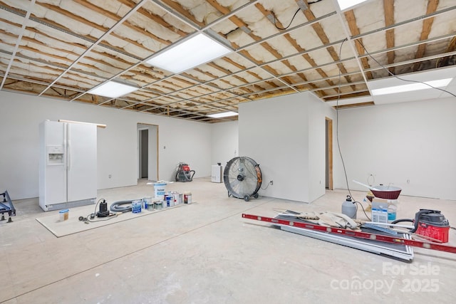 below grade area with white fridge with ice dispenser