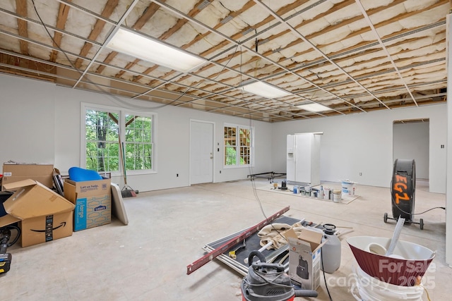 below grade area featuring white refrigerator with ice dispenser