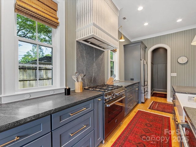 1614 Brook Rd, Charlotte, NC 28205 - kitchen with ornamental molding, light wood-type flooring, premium appliances, arched walkways, and blue cabinetry