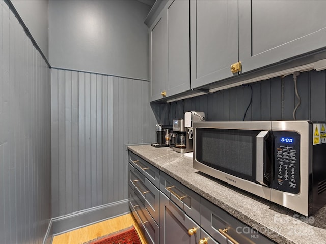1614 Brook Rd, Charlotte, NC 28205 - bar featuring stainless steel microwave, wooden walls, baseboards, and wood finished floors