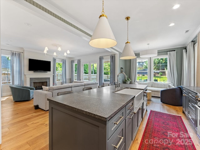 1614 Brook Rd, Charlotte, NC 28205 - kitchen with a sink, decorative light fixtures, a kitchen island with sink, light wood finished floors, and open floor plan