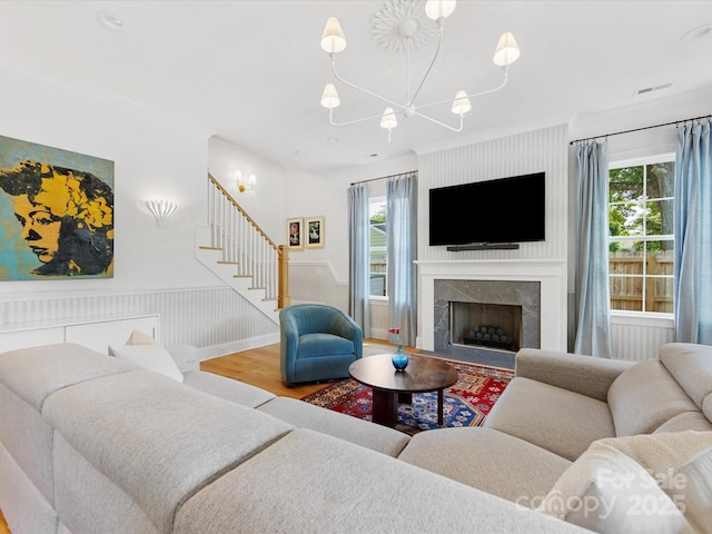 1614 Brook Rd, Charlotte, NC 28205 - living room with stairs, wood finished floors, a healthy amount of sunlight, a chandelier, and wainscoting