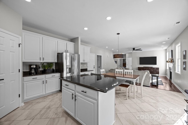 347 Wildbriar Rd Unit 28, Fletcher, NC 28732 - kitchen featuring ceiling fan, dark countertops, open floor plan, a kitchen island, and white cabinetry