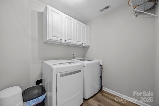 347 Wildbriar Rd Unit 28, Fletcher, NC 28732 - laundry area featuring independent washer and dryer, cabinet space, wood finished floors, and baseboards