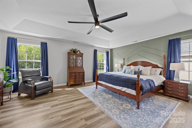 347 Wildbriar Rd Unit 28, Fletcher, NC 28732 - bedroom featuring a raised ceiling, multiple windows, light wood-type flooring, and a ceiling fan