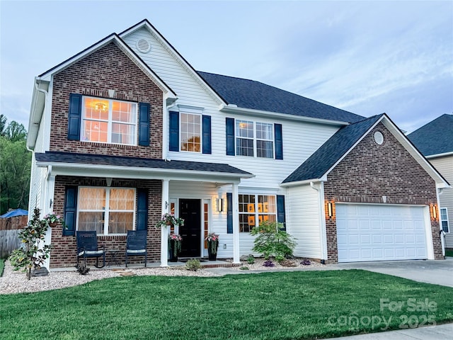 347 Wildbriar Rd Unit 28, Fletcher, NC 28732 - traditional home featuring brick siding, covered porch, a garage, a front lawn, and concrete driveway