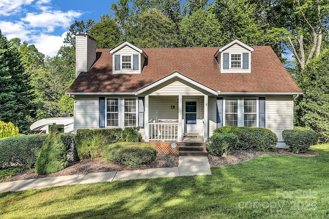 cape cod-style house featuring a porch, a chimney, a shingled roof, and a front yard
