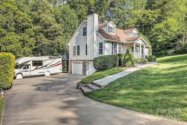 view of front of house with a porch, a chimney, a garage, a front lawn, and concrete driveway