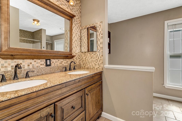 bathroom with a sink, a textured ceiling, and tasteful backsplash