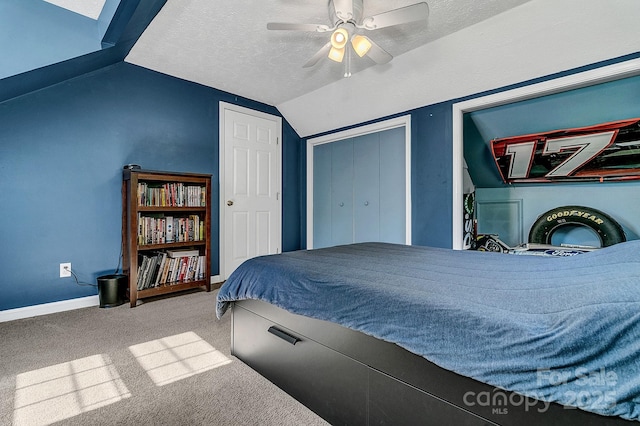 carpeted bedroom with a closet, lofted ceiling, baseboards, ceiling fan, and a textured ceiling