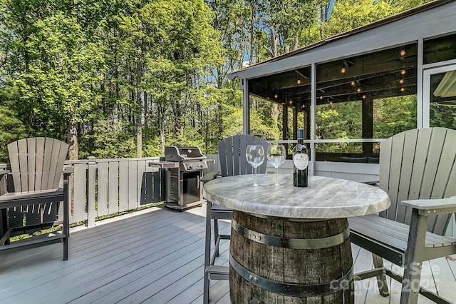 deck featuring outdoor dining space and a grill