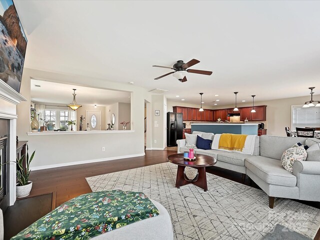 living area with dark wood finished floors, baseboards, visible vents, recessed lighting, and ceiling fan