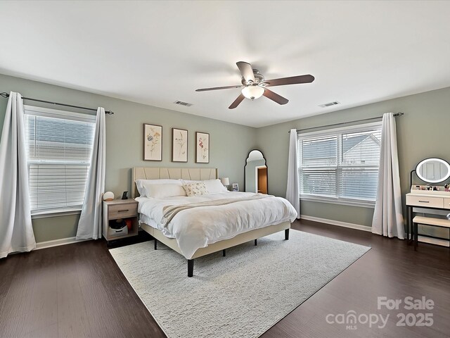 bedroom with baseboards, visible vents, and dark wood-type flooring