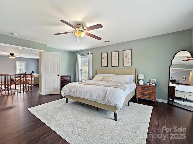 bedroom with baseboards, a ceiling fan, visible vents, and dark wood-style flooring
