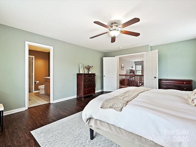 bedroom with wood finished floors, baseboards, ceiling fan, and ensuite bathroom