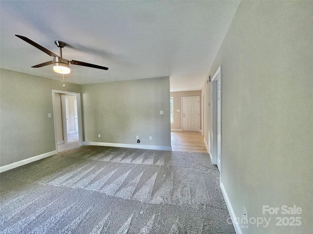carpeted empty room with ceiling fan and baseboards