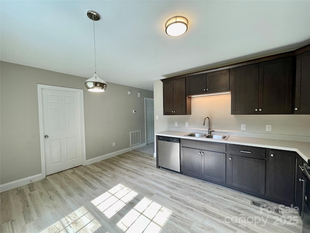 kitchen with dishwasher, a sink, light wood-type flooring, light countertops, and pendant lighting
