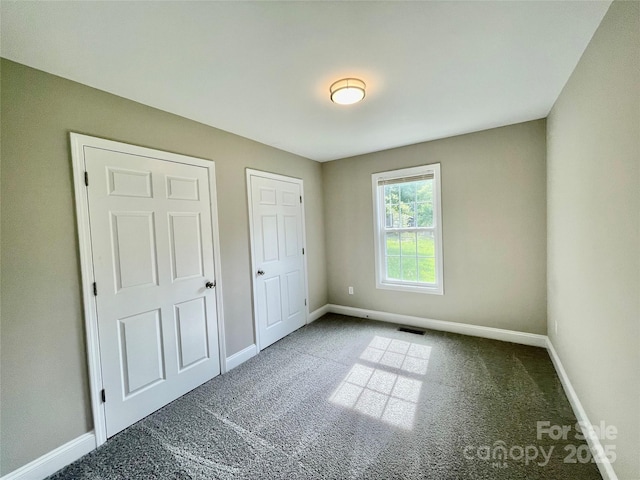 unfurnished bedroom featuring carpet and baseboards