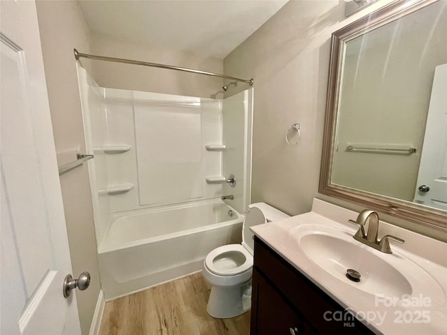full bathroom featuring toilet, wood finished floors, vanity, and shower / washtub combination