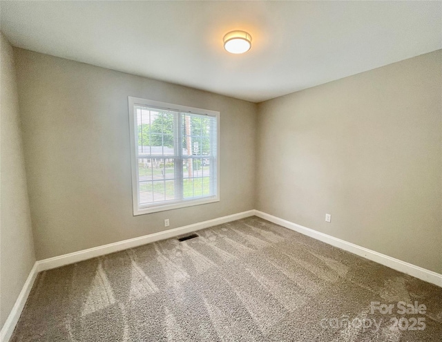 empty room with baseboards and carpet