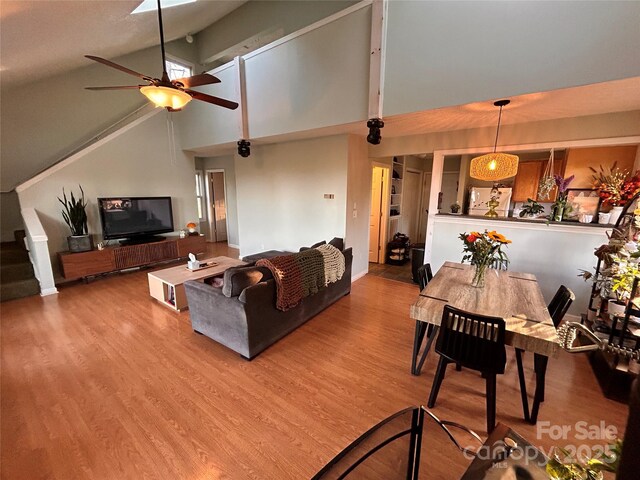 living room featuring wood finished floors, ceiling fan, and high vaulted ceiling