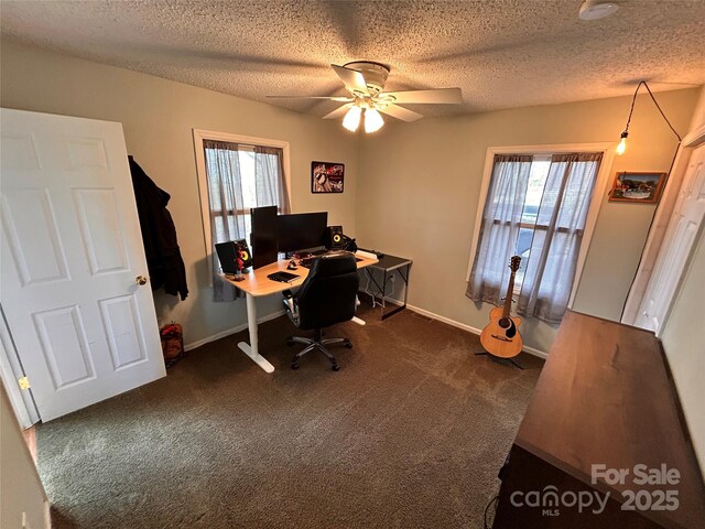 home office with ceiling fan, a wealth of natural light, dark colored carpet, and baseboards