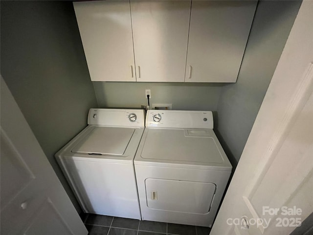 clothes washing area featuring dark tile patterned flooring, cabinet space, and independent washer and dryer