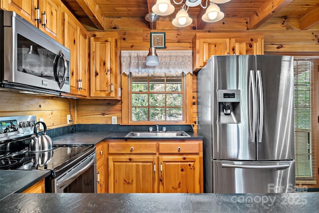 3110 Mentink Way, Nebo, NC 28761 - kitchen featuring appliances with stainless steel finishes, a sink, dark countertops, a chandelier, and wooden walls