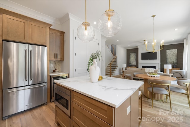 554 W Cama St, Charlotte, NC 28217 - kitchen with appliances with stainless steel finishes, ornamental molding, light wood-type flooring, a kitchen island, and a chandelier