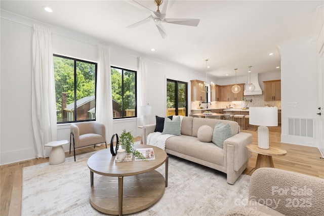 554 W Cama St, Charlotte, NC 28217 - living room featuring ceiling fan, light wood-style flooring, recessed lighting, crown molding, and baseboards