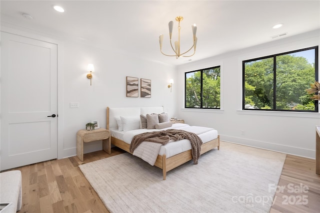 554 W Cama St, Charlotte, NC 28217 - bedroom with multiple windows, a chandelier, light wood finished floors, recessed lighting, and baseboards