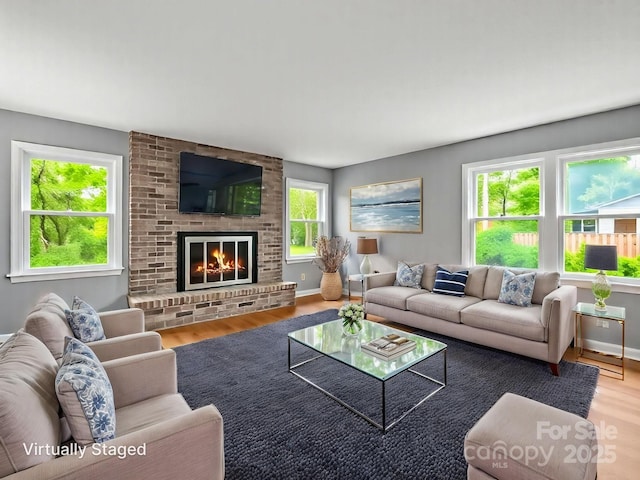 125 Snug Harbor Cir, Lake Lure, NC 28746 - living room with wood finished floors, baseboards, and a brick fireplace